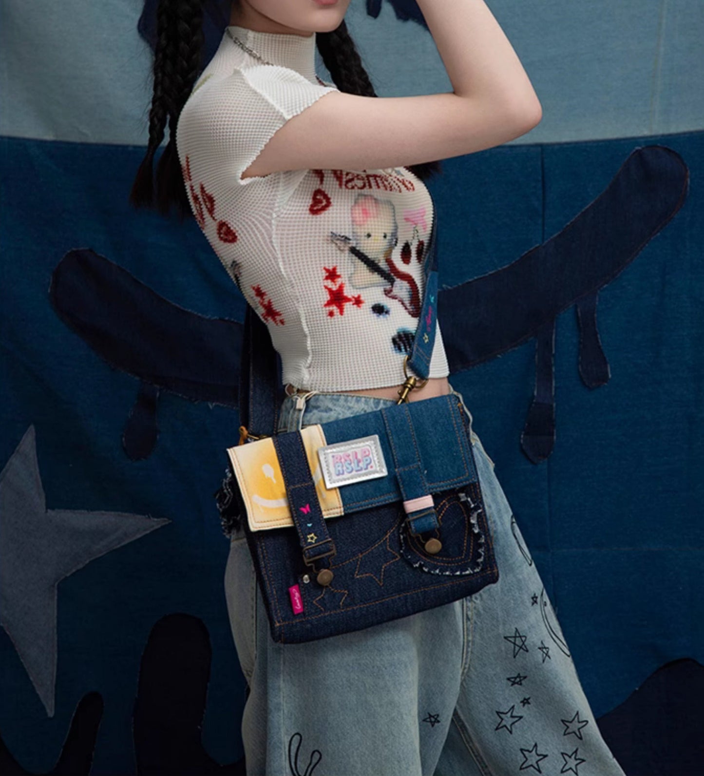 トレンディなデニムとイエローの生地のクロスボディバッグ。刺繍のアクセントと遊び心のあるチャームデザイン。ブルーデニムにイエローの生地、鮮やかで楽しい刺繍デザイン。カジュアルなお出かけ、旅行、普段使いにぴったりの、トレンディで遊び心のあるレディースバッグ。