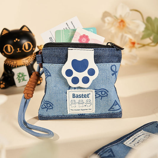 オリジナルデニムの猫の足跡コインケースデザイン。猫の足跡パッチとエジプト風プリントが施されています。可愛くて遊び心があり、普段使いやちょっとしたお出かけ、ギフトにも最適。猫の魅力がアクセントになり、小さな必需品を整理するのに最適。男女兼用。